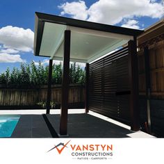 an outdoor pool area with a covered patio and swimming pool in the background, against a blue sky with wispy clouds