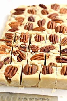 pecans are arranged on top of white frosted fudges in the shape of squares