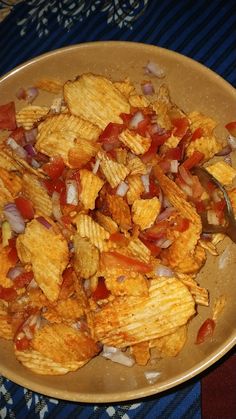 a bowl filled with chips and onions on top of a table