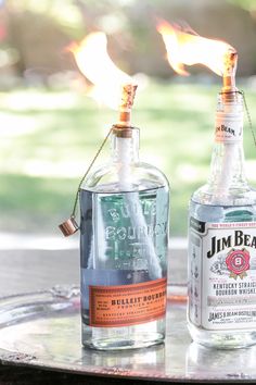 two bottles are sitting next to each other on a table with fire in the background