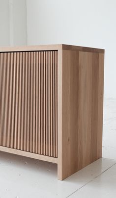 a wooden cabinet sitting on top of a white floor