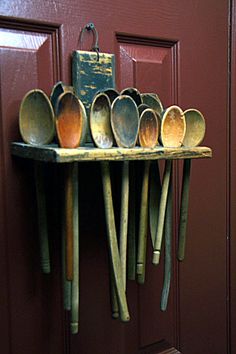 several spoons are lined up on a shelf in front of a door with a book