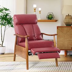 a red leather recliner chair and foot stool in a living room with white walls