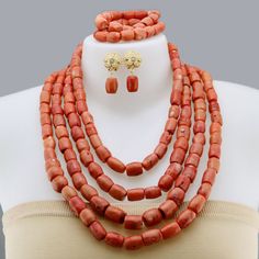 a necklace and earring set made out of red coral beads on a mannequin