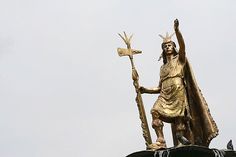 the statue is holding a cross and a sception on top of a building