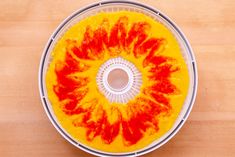 an overhead view of a food processor with red and yellow dye on the inside of it