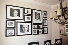 a dining room table with chairs and pictures on the wall above it, in front of a chandelier