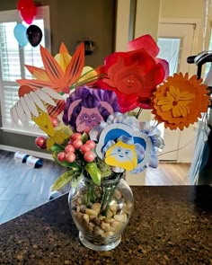 a vase filled with paper flowers on top of a counter