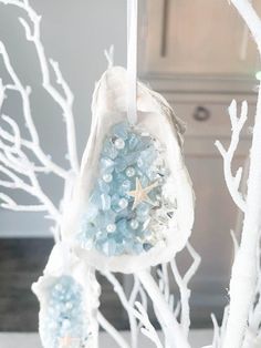 an ornament hanging from a tree with blue beads and starfish on it