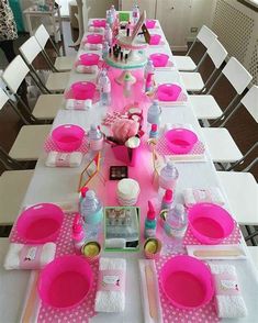 the table is set with pink and white dishes