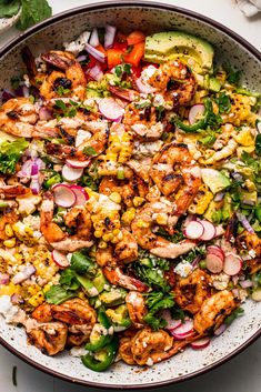 a bowl filled with shrimp and vegetables on top of a table