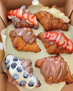 a box filled with pastries covered in chocolate and strawberries