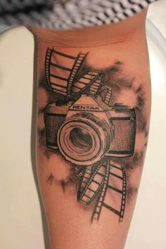 a black and white photo of a camera on someone's leg