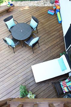 an overhead view of a deck with chairs and table on it, looking down at the patio