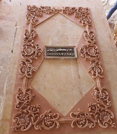 an ornately carved plaque on the side of a building with a name plate attached to it