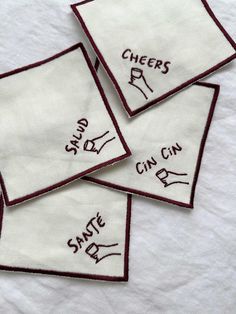 three embroidered napkins with words on them that say cheers and can't drink