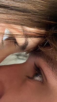 a close up of a woman's face with her hair blowing in the wind