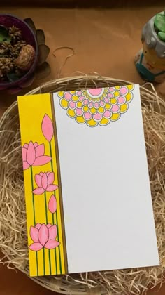 an empty notepad sitting on top of a basket filled with hay and other items