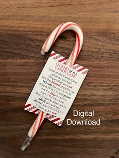 a candy cane with a poem on it sitting on top of a wooden table next to a piece of paper