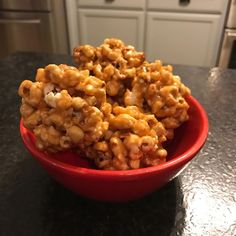 a red bowl filled with cereal on top of a counter