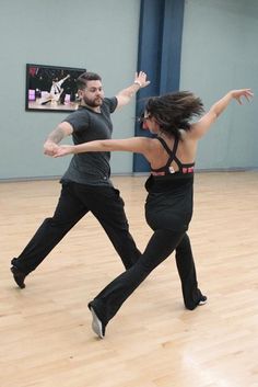 two people are dancing in an indoor dance studio