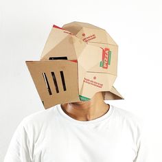 a man with a pizza box on his head and an open cardboard box over his face