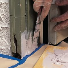 a person is painting the side of a building with white paint on it's walls