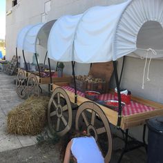 a woman kneeling down next to a wagon with food on it