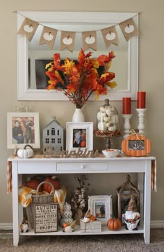 a white table topped with lots of pumpkins and other decorations on top of it