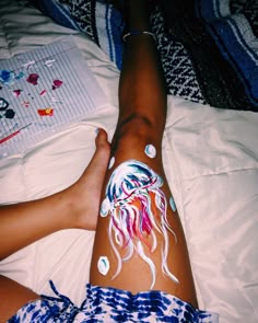 a person laying on a bed covered in white and blue paint with various stickers all over their body