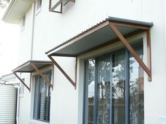 an outside view of a house with windows and awnings