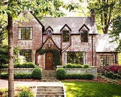 a large brick house with many windows and steps leading up to the front door area