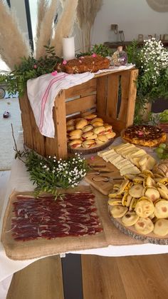 a table topped with lots of pastries on top of a wooden table covered in flowers