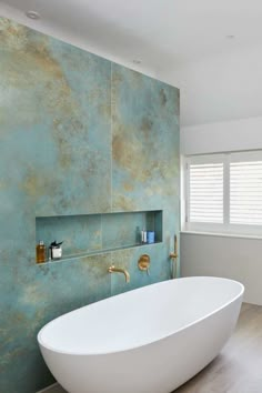 a bath tub sitting next to a window in a room with wooden floors and walls