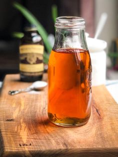 a glass jar filled with liquid sitting on top of a wooden table