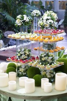 a table topped with lots of different types of flowers and candles next to each other