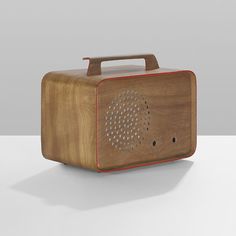 an old fashioned wooden radio on a white surface with a red trim around the top