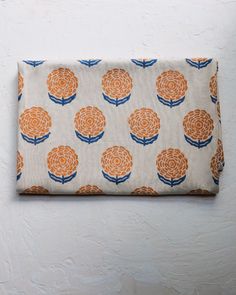 an orange and blue flowered pouch hanging on a wall