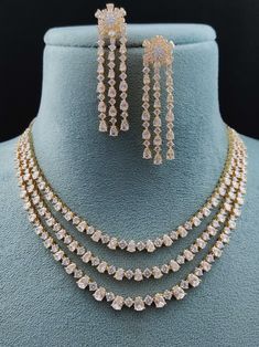 Experience the fusion of American innovation and Indian artisanship in our latest creation. Designed in the USA and meticulously handcrafted in India, this necklace set boasts american diamonds. Its design ensures effortless pairing with any ensemble, adding a touch of versatility to your jewelry collection. A symbol of boundless creativity and cross-cultural love, it's more than just a necklace – it's a statement of modern elegance. Handcrafted Metal: Metal Alloy, Gold Plated Necklace Set inclu Long Jewellery Necklace, Diamond Necklace Set Indian, Modern Indian Jewelry, American Diamond Necklace Set, Diamond Necklace Indian, Unique Locket, Bridal Necklace Designs, Fancy Jewelry Necklace, American Diamond Necklaces