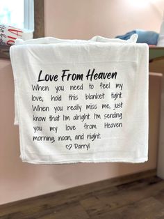 a tea towel hanging on a clothes line with the words love from heaven written on it