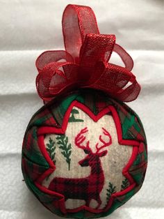 a red and green ornament with a deer on it