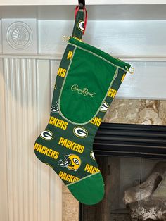 a green bay packers christmas stocking hanging from a fireplace