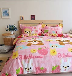 a bedroom with pink bedding and pictures on the wall above it, along with two nightstands