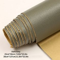 a roll of brown leather on top of a piece of paper with gold striping