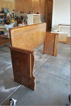 a wooden bed frame sitting on top of a floor next to a pile of boxes