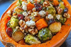 a bowl filled with brussel sprouts, carrots and nuts