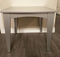 a grey table sitting on top of a hard wood floor