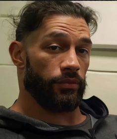 a close up of a man with a goatee and beard wearing a hoodie