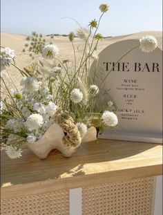 the bar is decorated with white flowers and greenery in front of an old tombstone