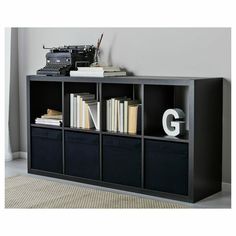 a bookcase with books and an old typewriter on top